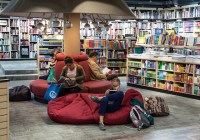 shelves with books, red seats, people reading