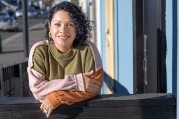 Author hedshot brown haired brown skin woman smiling in camera