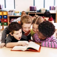 four children looking at a book