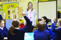 classroom, students in blue, teacher standing