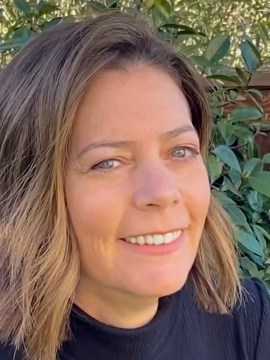 author headshot woman with blue eyes and brown hair smiling at camera