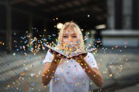 blonde woman, white t-shirt, book with confetti